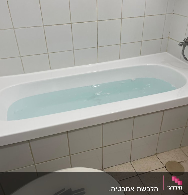 אמבטיה עם מים, אריחי קרמיקה לבנים על הקירות